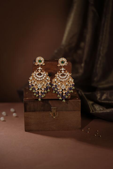 Indian gold-plated Chaandbali earrings featuring intricate Jadau Kundan work, pearls, and green and purple gemstone beads