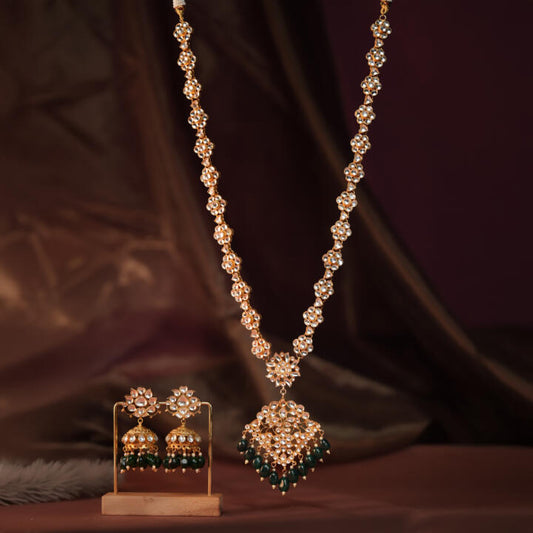 Long floral necklace with pendant design and emerald jhumkis in traditional style