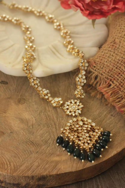 Long floral necklace with pendant design and emerald jhumkis in traditional style