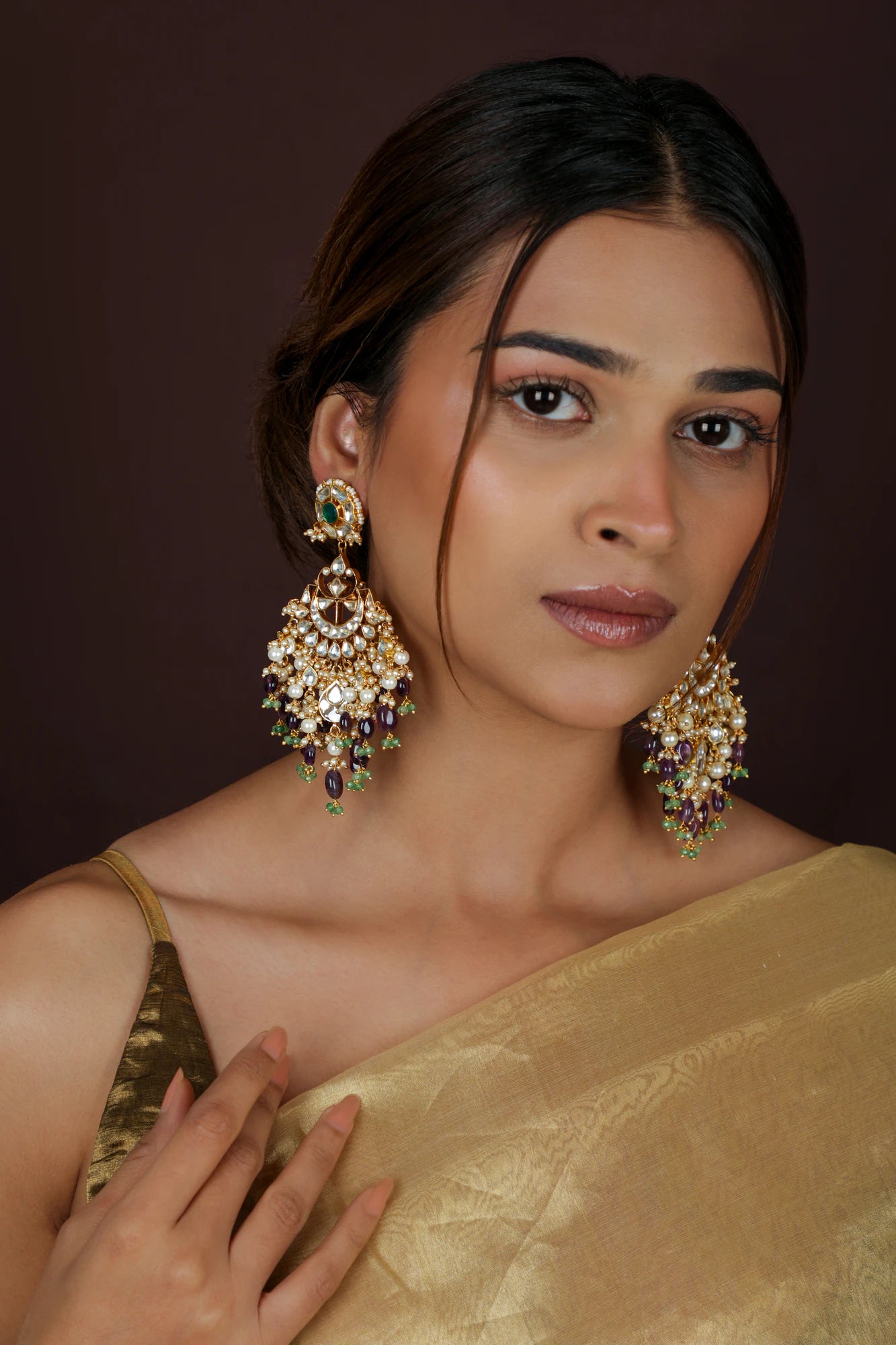 Indian gold-plated Chaandbali earrings featuring intricate Jadau Kundan work, pearls, and green and purple gemstone beads