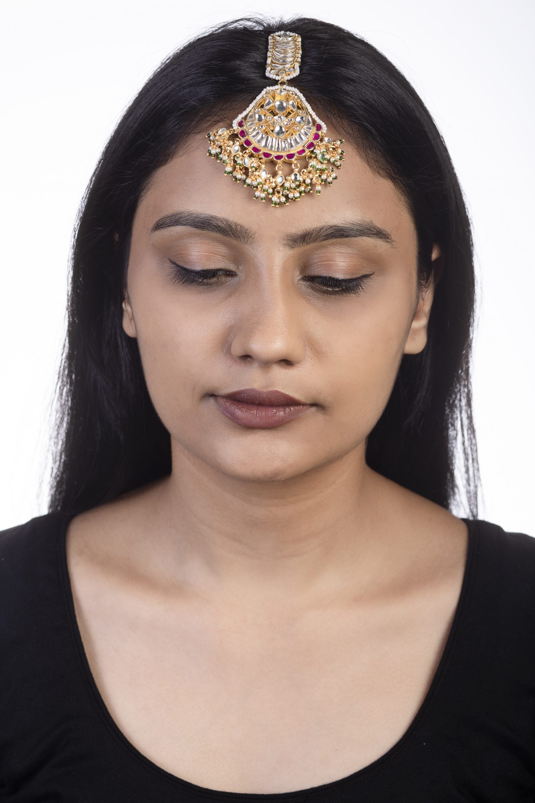 Maang tikka with pink jadtar stones and a touch of green with pearls