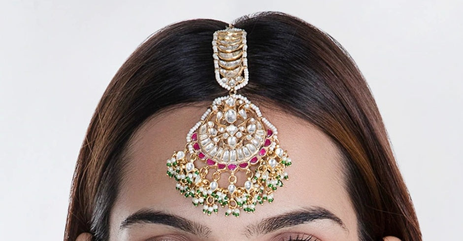 Maang tikka with pink jadtar stones and a touch of green with pearls